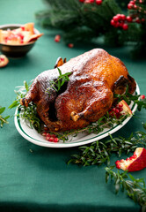 Roasted goose with delicious caramelized crust, served with pomegranate on a Christmas table