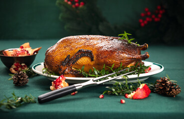 Roasted goose with delicious caramelized crust, served with pomegranate on a Christmas table © fortyforks