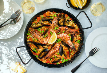 Seafood paella ready to eat served in a paella pan, top-down view