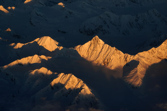 Nature scene - Aerial view of Snow Mountain and light of sunrise on the top  himalaya mountains from the plane at Leh Ladakh , Jammu and Kashmir , India - beautiful scene 