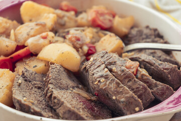 Close-up of a normal view of a platter with homemade meat stew with potatoes and carrots. Homemade food concept, natural food.
