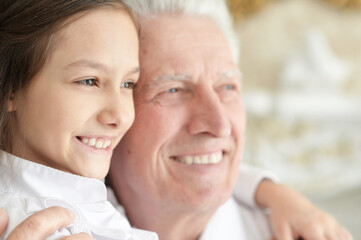 Happy elderly man with  cute granddaughter