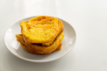 croutons of bread and egg in a plate on a white table.