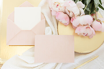 Wedding greeting card concept. Top view mockup on wooden background with peonies flowers. Flat lay style in light colors.