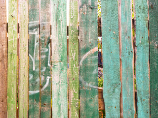 Old wooden fence with scratched green paint