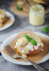 Egg benedict sandwiches - muffin with poached egg, ham and hollandaise sauce