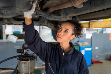 Service repair maintenance concept. African American woman work for auto mechanic in garage...