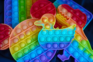 colorful different forms antistress sensory toys fidget push pop it on a blue fabric background