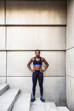 Confident black sportswoman standing on steps