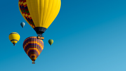 Hot Air Balloon Ride on blue sky background. Ballooning flights in Cappadocia, panoramic landscape for your tour agency promotion.