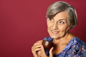Fototapeta premium Close up portrait of beautiful smiling senior woman drinking tea