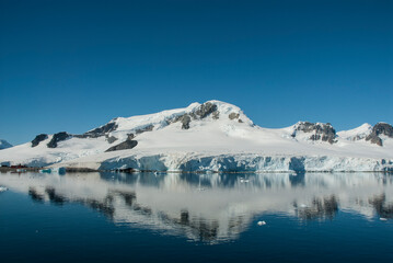 Fototapeta na wymiar Snowy mountains in sunny day, Paraiso Bay, Antartica.
