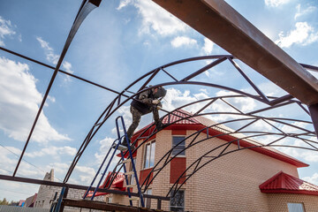 A worker welds metal to the canopy. Technologies