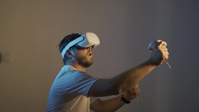 young man wearing Virtual Reality   VR Headset. VR for gaming. Man play game in VR glasses. Hipster with virtual reality headset. 