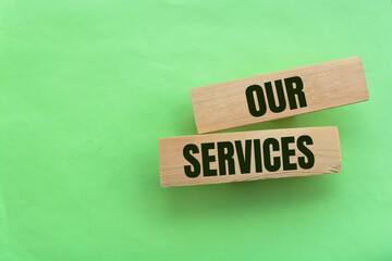 Wooden blocks with the text 'our services' on beautiful blue background. Business concept, copy...