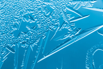 Blue patterns from frost on glass as a background.