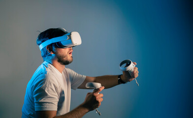 young man wearing Virtual Reality   VR Headset. VR for gaming. Man play game in VR glasses. Hipster...
