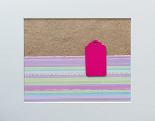 isolated pink retro wooden tag on a craft and striped paper background with accent frame