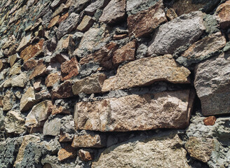 The masonry wall is made of large natural granite blocks.