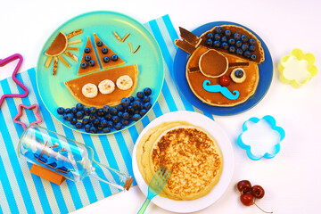 Fun food. Pancakes with berries for kids. pirate and ship boat. Breakfast for children.	