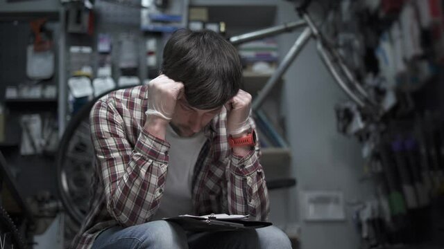 Individual entrepreneur analyzes costs bicycle shop. Concept small business owner bankruptcy, financial problems and crisis, money overspend. Business is going down. Depressed male checking finance.
