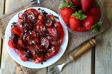 Strawberries with chocolate on a plate. Fresh juicy strawberries. Summer healthy dessert.