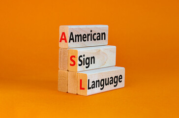 Naklejka premium ASL, american sign language symbol. Wooden blocks with words 'ASL, american sign language'. Beautiful orange background. Medical and ASL, american sign language concept. Copy space.