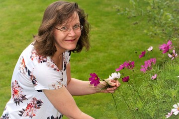 Adele cutting Cosmos flowers, in July, 2021.