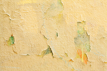 Stucco background, aged yellow cement wall texture with cracked paint