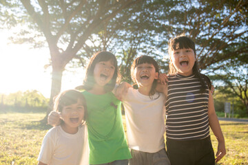 Group of kindergarten kids friends arm around and smiling fun With sunset