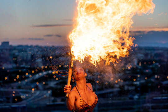 Fire-eater artist performing spit fire at sunset