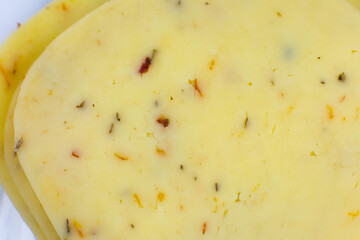 Yellow cheese with herbs and spices background Texture . Close up, macro photo.