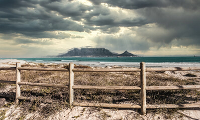 Dramatic sky vista of Table Mountain from the dunes of Big Bay, Cape Town South Africa