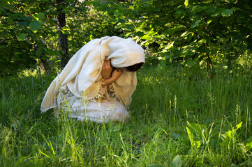 Praying woman on grass lawn