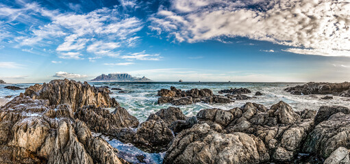 Scenic vista of Table Mountain, Cape Town, South Africa. A stunning view from Table View beach - across the bay where tourists and surfers alike come to enjoy the beach and ocean.