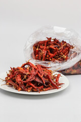 Fototapeta premium red dried chili hot spicy in white dish blurred background plastic bag chili and copy space