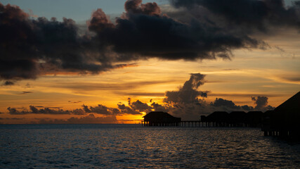 Sunset in the Maldives. Black clouds over the sea.
