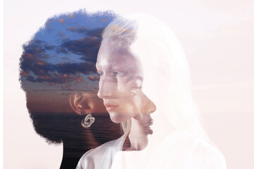Caucasian woman and african american woman multiple exposure portrait on sky background. Women...