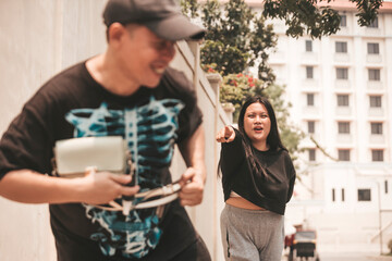 A frightened woman screams and points to a thief who snatched her bag getting away.