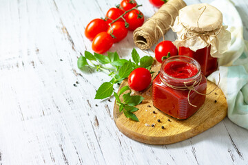 Tomato paste, home preservation. Tomato sauce made from ripe tomatoes on a wooden tabletop. Copy space.