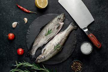 raw fish trout with spices ready for cooking, on a stone background 