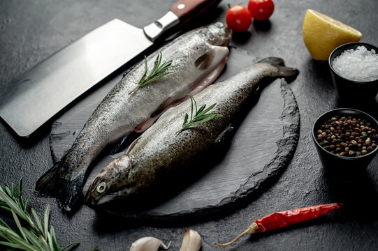 raw fish trout with spices ready for cooking, on a stone background 