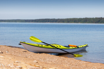 Yellow kayak on the shore of the bay. Kayaking tour, active water sports.
