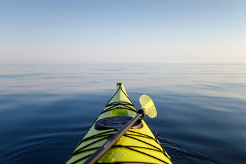 Yellow kayak with a paddle close-up in focus. The background of the sea is blurred. Active water...