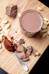 Glass of chocolate cream cocktail on a wooden table close up