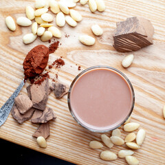 Almond milk in a glass cup on a wooden table. Almond milk with cocoa
