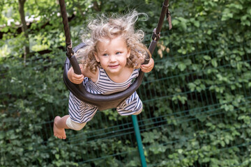 petite fille joue sur une balançoire, elle se balance et vole.