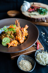 Pad Thai - stir-fried rice noodles with dried salt shrimp and tofu on wooden board - Asian food style
