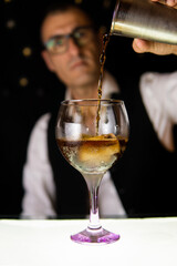 Barman preparing cocktails in a disco bar with a shaker