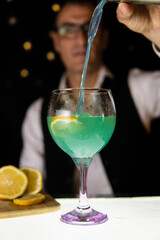 Barman preparing cocktails in a disco bar with a shaker